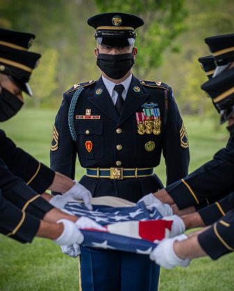 Member of the US Army Old Guard fold a flag during a service at Arlington National Cemetery during the COVID pandemic | arlington funeral service | Arlington Media, Inc.