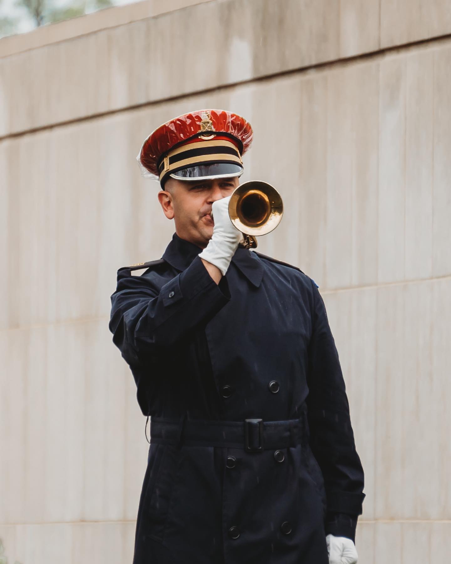 A bugler from the U.S. Army Band, "Pershing's Own", plays Taps during modified military funeral honors for a U.S. Army Service outside of Court 8 of the Columbarium at Arlington National Cemetery, Arlington, Virginia in June of 2020, during a rainstorm.