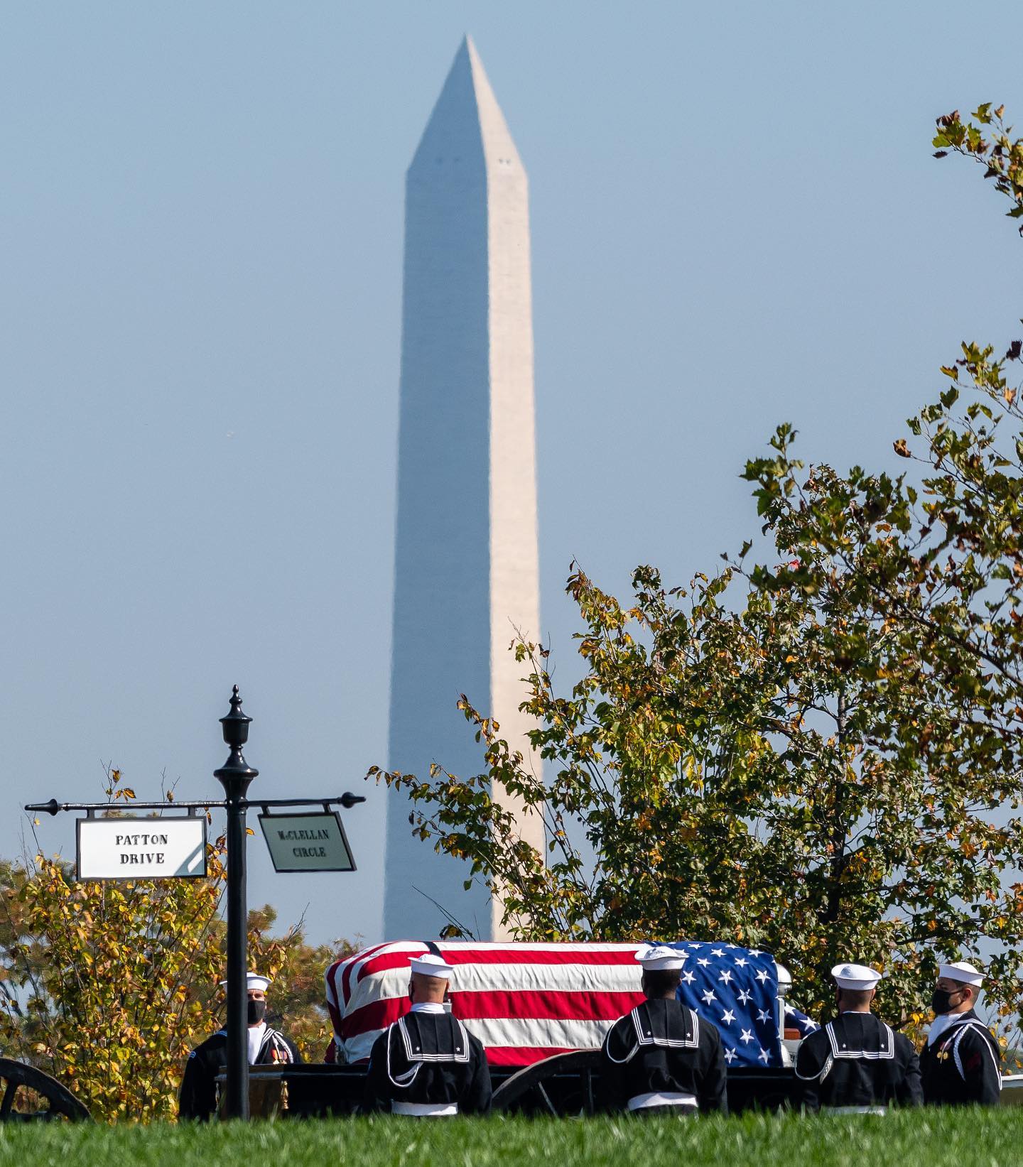 A ceremonial procession halts under the shadow of the Washington Monument along Patton Drive in Arlington National Cemetery, Arlington, Virginia.