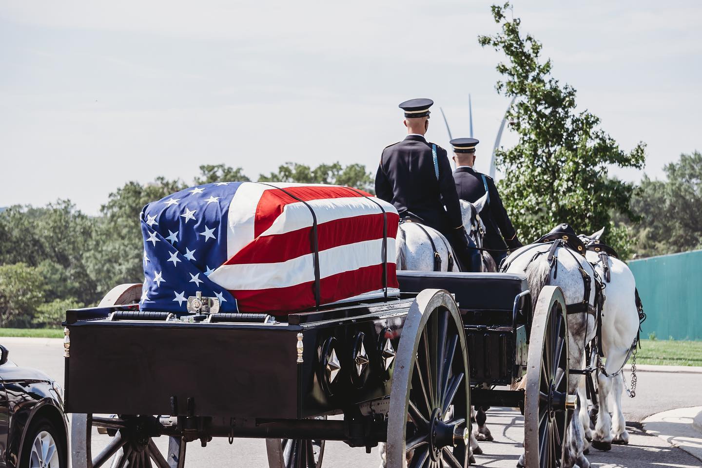 A United States burial casket flag drapes the casket of deceased veterans to honor the memory of their service to the country. The ceremonial folding and presentation of the flag is a moving tribute of lasting importance to the veteran's family, something we at Arlington Media, are honored to both witness and capture behind our lens. 

The flag is placed on a closed casket so the union blue field is at the head and over the left shoulder of the deceased. Something that can be seen here, as the Caisson team leads a procession under the shadow of the Air Force Memorial. 

After Taps is played, the flag is carefully folded into the symbolic tri-cornered shape. A properly proportioned flag will fold 13 times on the triangles, representing the 13 original colonies. The folded flag is emblematic of the tri-cornered hat worn by the Patriots of the American Revolution. When folded, no red or white stripe is to be evident, leaving only the blue field with stars. 

It is then presented as a keepsake to the next of kin or an appropriate family member.