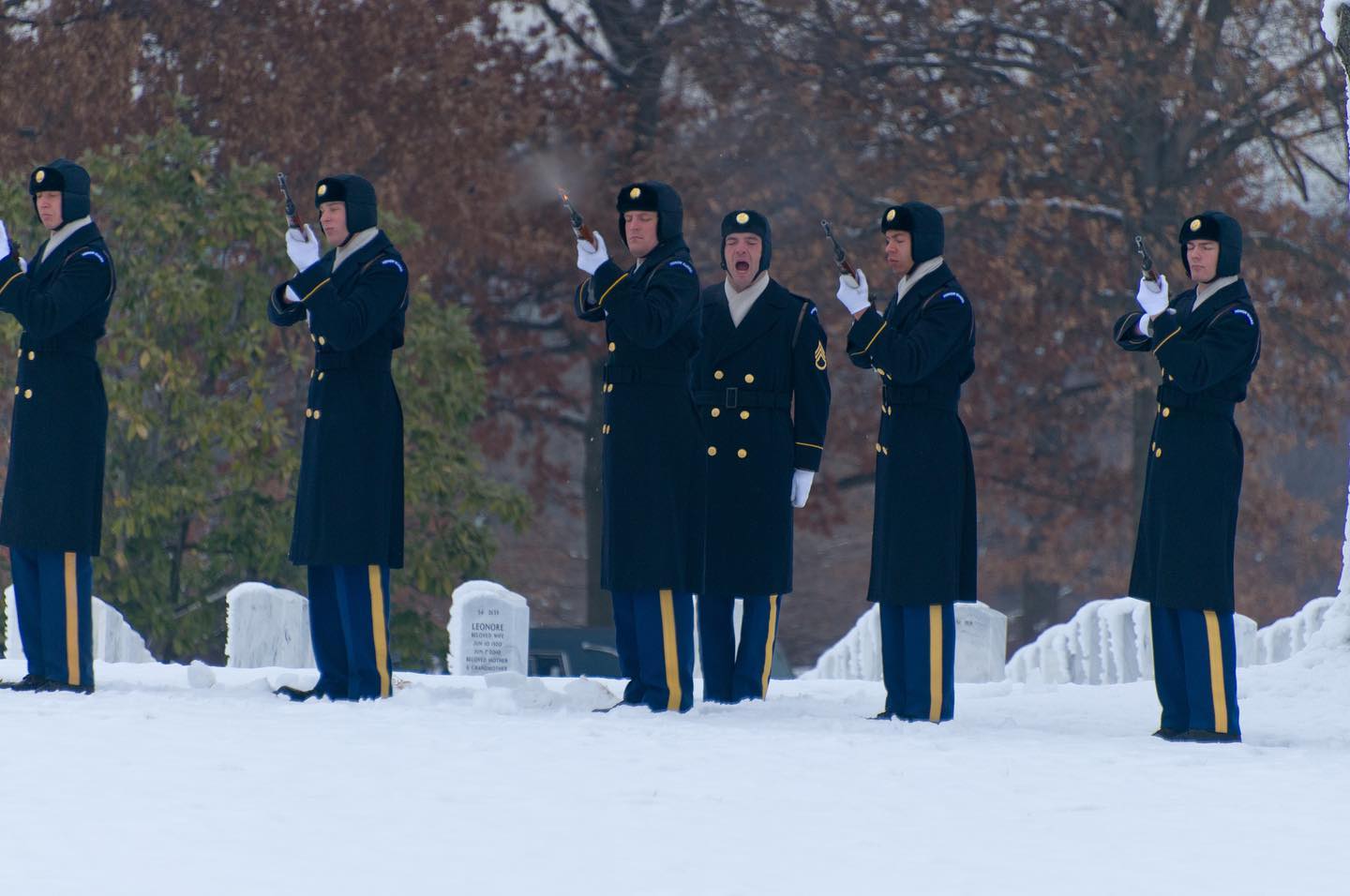 Soldiers in the US Army Old Guard fire three volleys during a funeral in the snow at Arlington National Cemetery.