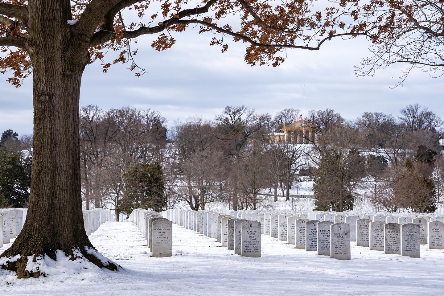 Seen towering above the graves in Section 54, dusted with a fresh coating of snow is the Arlington House. 

Before Arlington National Cemetery ever existed, it was Lee’s Arlington estate. But after Lee resigned from the U.S. Army to lead the Confederate forces, the property was occupied by the Army and later purchased by the U.S government in 1864. As Washington area hospitals overflowed with Civil War casualties, the estate was designated a national cemetery.

After the war, several Union leaders were concerned that Lee would try to reclaim his property and remove the graves and tombs. One of these people, Quartermaster General Montgomery Meigs, decided that the best way to ensure the cemetery’s permanence was to bury soldiers as close to the main house as possible. He got his way in August of 1864, when 26 fallen soldiers were buried by the perimeter of Lee’s rose garden.

This might seem like an extreme measure, but there is proof that the Lees had an interest in returning to their estate and dislocating soldiers’ graves in the process. Robert E. Lee’s brother, Smith Lee, is recorded to have said “the house could still be made a pleasant residence, by fencing off the Cemetery, and removing the officers buried around the garden.”

However, the plan to move the graves even closer seemed to have worked. Robert E. Lee never returned to his Arlington estate. No one knows if it was because his front lawn became a graveyard or because he had just had enough with the Washington area, but Lee moved to Lexington, Virginia and died five years later. He is buried at Lee Chapel in Lexington, and not in Arlington Cemetery where he once lived.