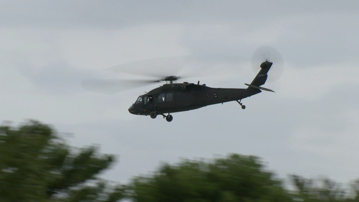 A U.S. Army Blackhawk helicopter is seen rising above the graves at Arlington National Cemetery.