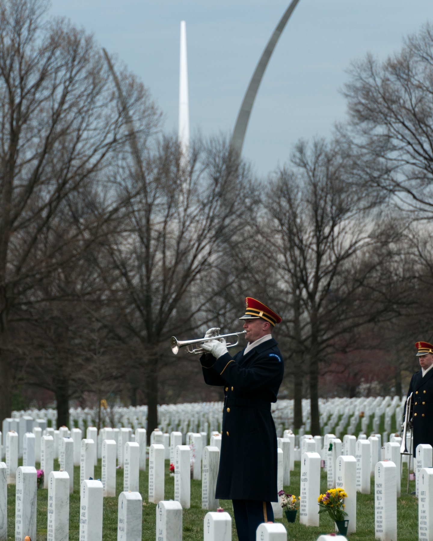 A US Army Band Bugler plays Taps under the shadow of the US Air Force Memorial.

The Air Force Memorial structures represent the long history of air and space aviation from the balloon reconnaissance, through Orville Wright’s first military flight at Fort Myers, to the Air Force of today. The Air Force Memorial provides a visual representation of the cumulative history of the United States Air Force. The Air Force Memorial uses design, inscriptions and sculpture to represent the Air Force heritage including those intrepid pioneers in balloon reconnaissance and the advent of manned flight in air and space.

The design of the Air Force Memorial symbolizes reaching for the stars, soaring above the earth and executing a bomb burst maneuver, best demonstrated by the United States Air Force Thunderbirds. Our tribute and honor to the Airmen heritage is represented in the 8-foot tall bronze United States Air Force Honor Guard, standing watch over the Memorial grounds.