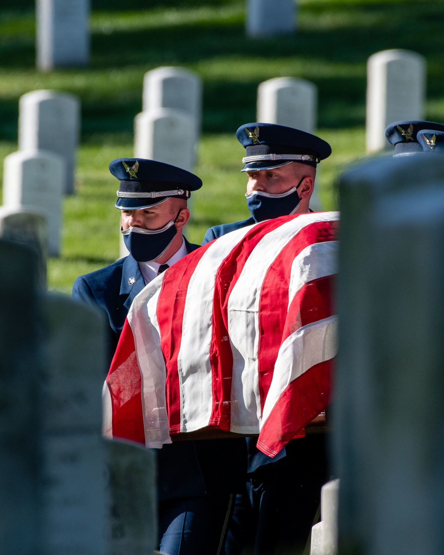 Members of the US Air Force Honor Guard carry a casket through Section 25 of Arlington National Cemetery.