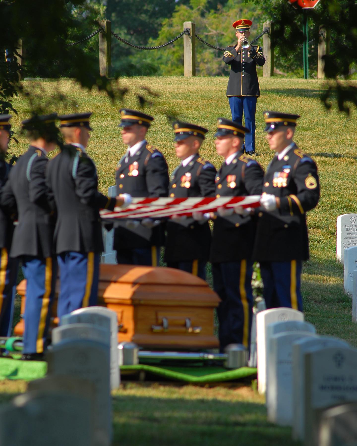 A @usarmyband bugler can be seen behind members of The Old Guard as they perform Taps in honor of a veteran.  Photograph captured by Arlington Media photographers.

There are several legends concerning the origin of "Taps". The most widely circulated one states that a Union Army infantry officer, whose name often is given as Captain Robert Ellicombe, first ordered "Taps" performed at the funeral of his son, a Confederate soldier killed during the Peninsula Campaign. 

This apocryphal story claims that Ellicombe found the tune in the pocket of his son's clothing and performed it to honor his memory, but there is no record of any man named Robert Ellicombe holding a commission as captain in the Army of the Potomac during the Peninsula Campaign.

Another, perhaps more historically verifiable, account of "Taps" first being used in the context of a military funeral involves John C. Tidball, a Union artillery captain who during a break in fighting ordered the tune sounded for a deceased soldier in lieu of the more traditional—and much less discreet—three volley tribute. Army Col. James A. Moss, in an Officer's Manual initially published in 1911, reports the following:

During the Peninsula Campaign in 1862, a soldier of Tidball's Battery A of the 2nd Artillery was buried at a time when the battery occupied an advanced position concealed in the woods. It was not safe to fire the customary three volleys over the grave, on account of the proximity of the enemy, and it occurred to Capt. Tidball that the sounding of Taps would be the most appropriate ceremony that could be substituted.

While not necessarily addressing the origin of "Taps", this does represent the first recorded instance of "Taps" being sounded as part of a military funeral. Until then, while the tune had meant that the soldiers' day of work was finished, it had little to none of the connotation or overtone of death, with which it so often is associated today.