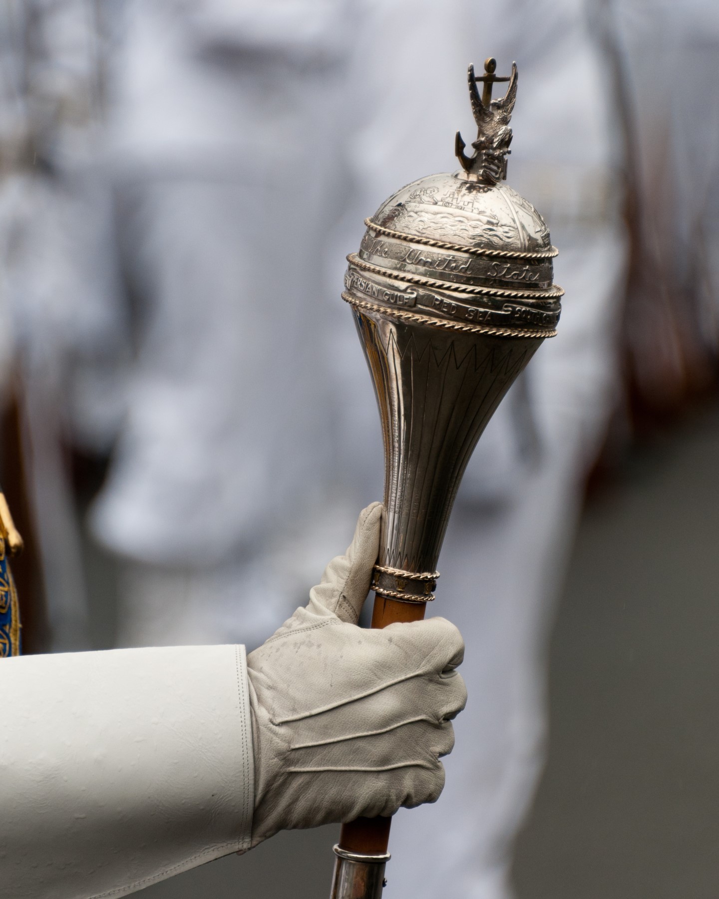 The US Navy Ceremonial Band Baton held by the Drum Major is pictured here in a capture by @arlingtonmedia during ceremonial honors.

The Navy Ceremonial Band performs music at official military and government functions as well as other special events. Led by the Navy Band drum major, the group’s varied duties include arrival ceremonies at the White House and Pentagon, changes of command, military retirement ceremonies and funerals at Arlington National Cemetery. 

The ceremonial band also supports the Navy’s mission by providing music for community events around the Washington area. Regularly staffed by approximately sixty musicians who rotate between the Ceremonial and Concert Bands, the Ceremonial Band’s size may vary from 15 to 99 pieces based on mission requirements. 

The ensemble is routinely augmented with members from other Navy Band performing groups when very large ceremonial bands are required. 

The Ceremonial Band provides support for more than 1,300 official ceremonies annually.  Navy Band drum majors are keenly aware of the centuries of tradition the sash and mace represent. They truly are the leaders and mentors to which the entire band looks for guidance and direction on the command’s top mission priorities. They lead the way.