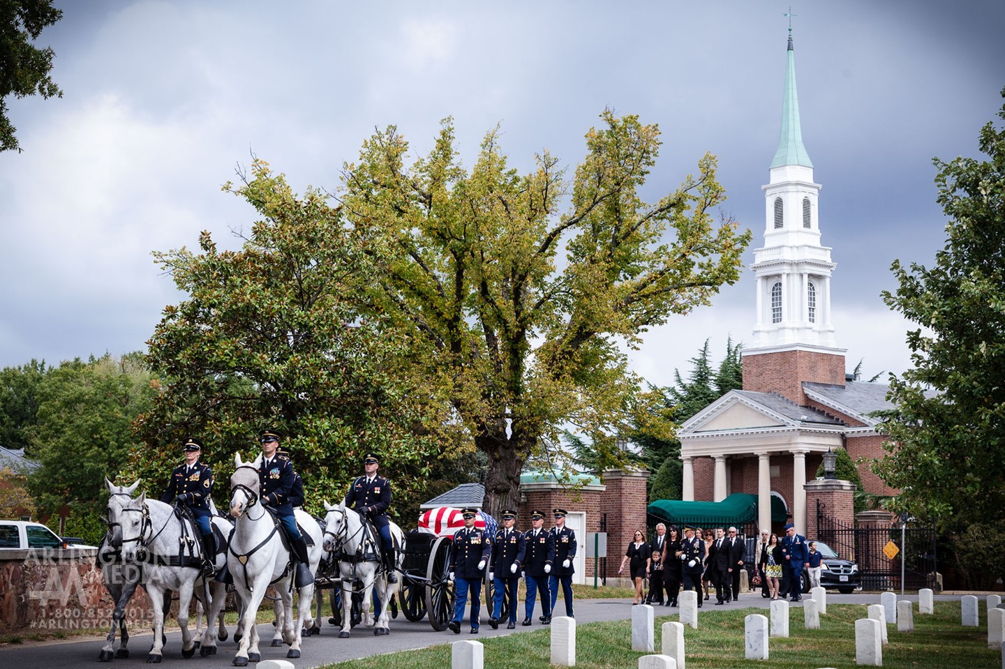 A US Army Full Honors service departs the Old Post Chapel at Fort Myer and enters Arlington National Cemetery on the way to the gravesite.

The Old Post Chapel on Fort Myer is adjacent to Arlington National Cemetery and is the site of many military funerals. The chapel is striking in its simplicity and its unique stained glassed windows which add to its beauty. The windows were donated by the chaplain corps of the different branches of the services -- with depictions from each branch. 

While services take place in the chapel, the gravesite can be up to 2 miles away in the cemetery itself.  After the church service, the casket is placed on a caisson pulled by six horses. Behind the caisson, family and friends may choose to walk or drive their car to the burial site.  This scene is shown here, as captured by our @arlingtonmedia team
