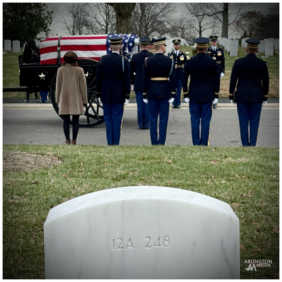 A caisson arrives at the gravesite of an honored veteran in Arlington National Cemetery.

In this image captured by our team, a woman can be seen standing to the far left of the soldiers.  This is a common sight at Arlington National Cemetery and this individual holds a special role. 

She is what is known as an "Arlington Lady".

In the words of ANC, "The Arlington Ladies are a group of volunteers who attend funeral services at Arlington National Cemetery to ensure that no Soldier, Sailor, Airman or Coast Guardsman is buried alone.

The Arlington Ladies began in 1948 within the Air Force. The Chief of Staff of the Air Force, General Hoyt Vandenberg, and his wife, Gladys, routinely attended funeral services at the cemetery and noticed that some services had only a military chaplain present. The Vandenbergs believed that a member of the Air Force family should also attend, and Mrs. Vandenberg asked her friends to start attending services. She ultimately formed a group from the Officer's Wives Club. In 1973, General Creighton Abrams' wife, Julia, founded the Army's version of the group. In 1985, the Navy created a group, and in 2006 the Coast Guard followed suit. The Marines do not officially have a group, as they send a representative of the Marine Commandant to every funeral.

Today, the Air Force, Army, Navy and Coast Guard all have Arlington Ladies who perform similar volunteer duties, attending funeral services for active duty service members and veterans. The criteria to become an Arlington Lady is different for each military service, but each Lady has some connection to the respective service, generally as a current or former military member or as a spouse of a military member. The Ladies are an official part of the funeral service, representing the military service's chief of staff or equivalent. They present cards of condolence to the next of kin from the military service chief and spouse on behalf of the service family, and from the Arlington Lady herself."

PC: @arlingtonmedia