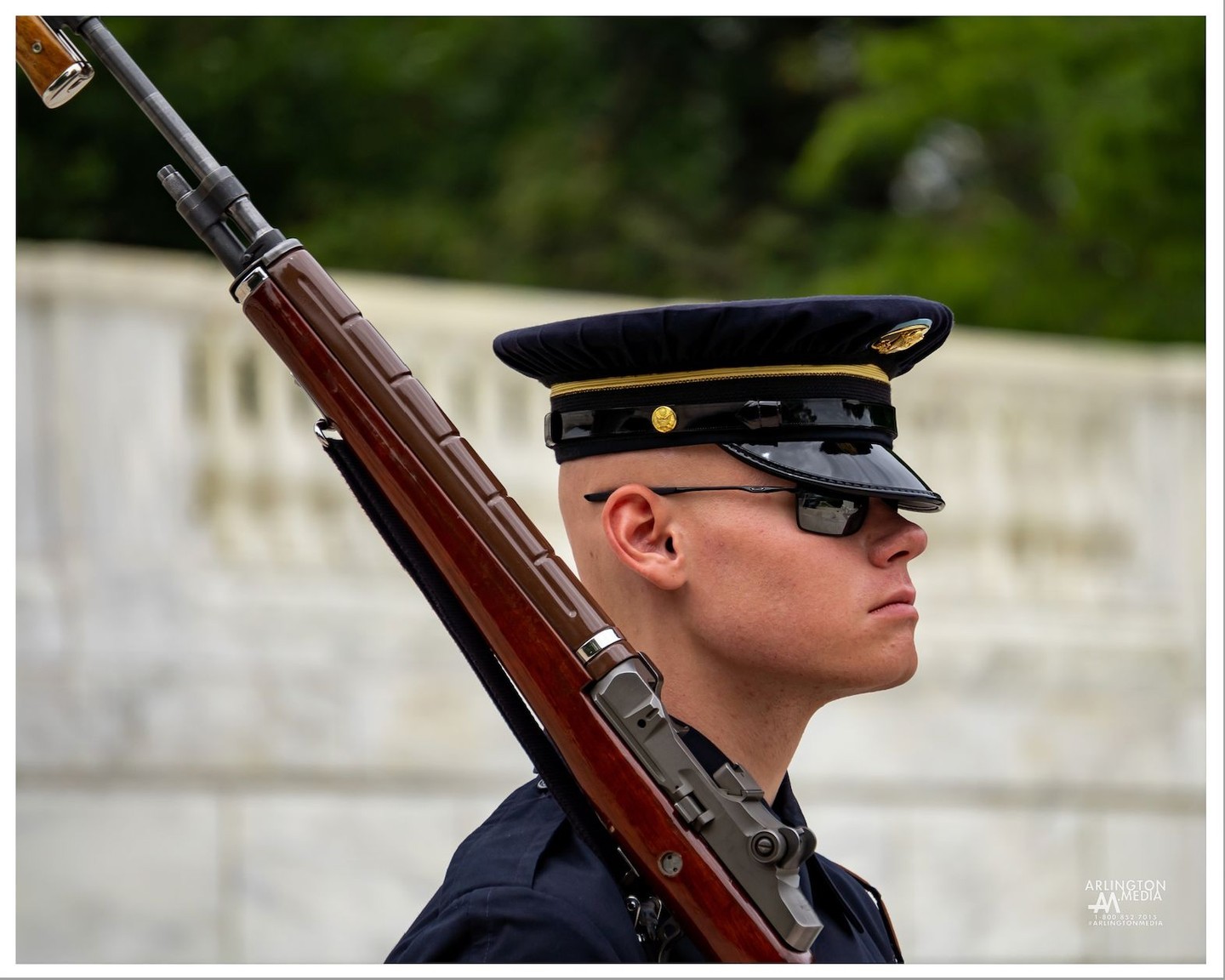 Twenty-four hours a day, soldiers from the 3rd U.S. Infantry Regiment, known as "The Old Guard," stand watch over the Tomb. The Tomb Guards, also called Sentinels, are chosen for this prestigious and highly selective post only after rigorous training and a demanding series of examinations (see below). The Old Guard has held this distinguished duty since 1948. 

An impeccably uniformed relief commander appears on the plaza to announce the changing of the guard. Soon, the new Sentinel leaves the Tomb Guard quarters and unlocks the bolt of his or her M-14 rifle, signaling to the relief commander to begin the ceremony. The relief commander walks out to the Tomb and salutes, then faces the spectators and asks them to stand and remain silent during the ceremony.

The relief commander conducts a detailed white-glove inspection of the weapon, checking each part of the rifle once. Then, the relief commander and the relieving Sentinel meet the retiring Sentinel at the center of the black mat in front of the Tomb. All three salute the Unknown Soldiers who have symbolically been given the Medal of Honor. The relief commander orders the relieved Sentinel, "Pass on your orders." The current Sentinel commands, "Post and orders, remain as directed." The newly posted Sentinel replies, "Orders acknowledged," and steps into position on the mat. When the relief commander passes, the new Sentinel begins walking at a cadence of 90 steps per minute.

The Tomb Guard marches exactly 21 steps down the black mat behind the Tomb, turns, faces east for 21 seconds, turns and faces north for 21 seconds, then takes 21 steps down the mat and repeats the process. (The number 21 symbolizes the highest military honor that can be bestowed, the 21-gun salute.) Next, the Sentinel executes a sharp "shoulder-arms" movement to place the weapon on the shoulder closest to the visitors, signifying that he or she stands between the Tomb and any possible threat. - Arlington National Cemetery