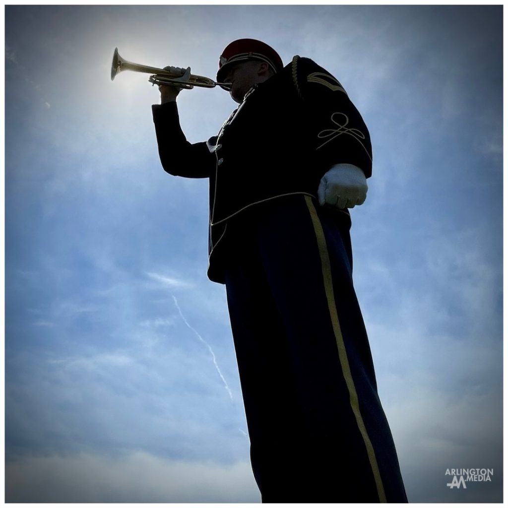 A US Army Band bugler plays taps at a full honors funeral at Arlington