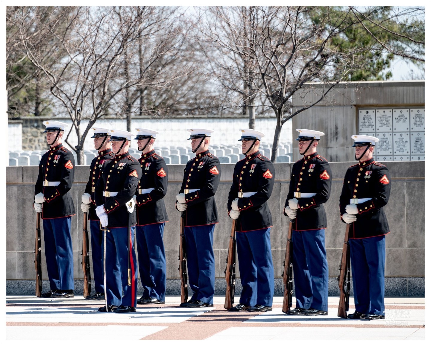 A US Marine Corps rifle platoon stands ready for a service on Nimitz Drive. 

Military funerals have their own rites and traditions that have evolved through the ages. The returning of the dead, preparation of the body, funeral service with orations, procession to place of interment (with escorts and music), graveside rites, etc…, all have their roots from antiquity.

Today’s customary three volleys fired over a grave probably originated as far back as the Roman Empire. This custom is incorrectly referred to as a “21-gun-salute”.